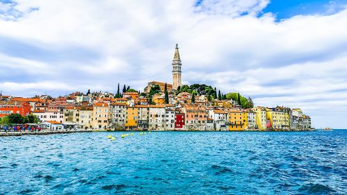 View of sea and buildings against cloudy sky rovinj