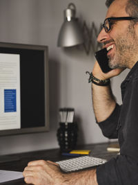 Midsection of man using mobile phone on table