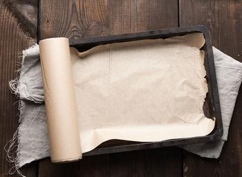 Empty rectangular metal pan covered with brown parchment paper and 