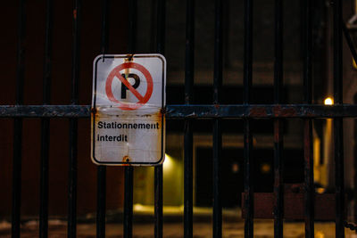 Close-up of warning sign on metal fence