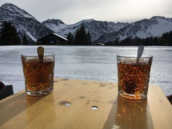 Close-up of ice cream on table against mountains during winter