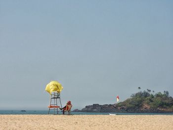 Man on beach against clear sky