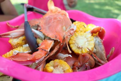 Close-up of crabs and corns in container