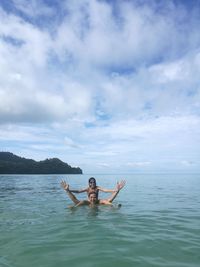 Portrait of father and daughter in sea against sky