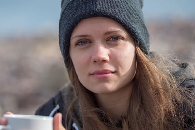 Close-up portrait of woman wearing knit hat