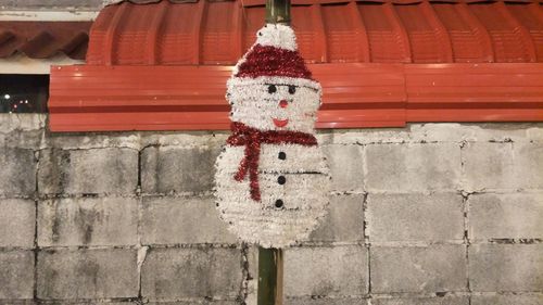 Close-up of decoration hanging on brick wall