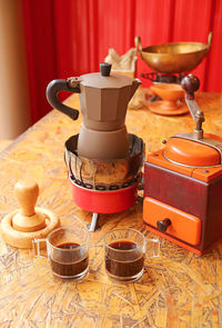 Two cups of fresh brewed espresso with retro coffee maker set on a table