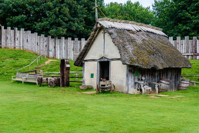 Built structure on field against trees and building