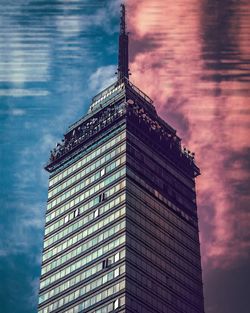 Low angle view of modern building against cloudy sky