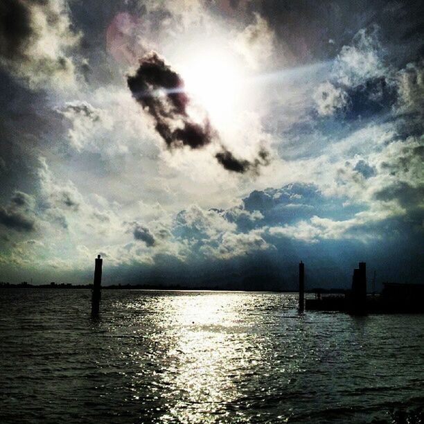 water, waterfront, sky, sea, silhouette, cloud - sky, built structure, rippled, tranquility, architecture, tranquil scene, scenics, nature, sun, beauty in nature, cloud, river, sunset, cloudy, sunlight