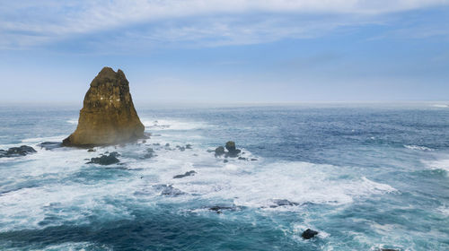 Rocks in sea against sky