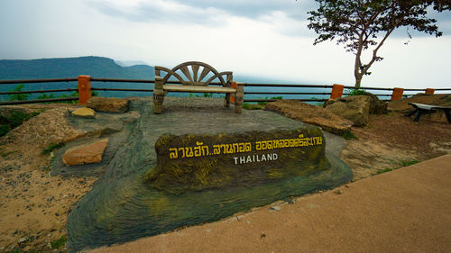 Information sign on beach against sky