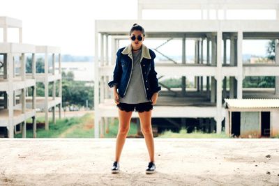 Portrait of a young woman standing on railing