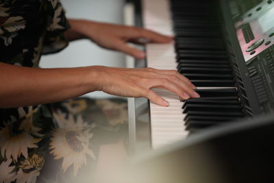 Midsection of person playing piano