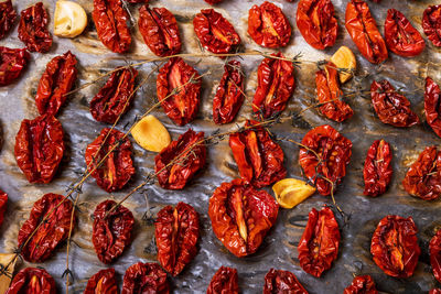 Close-up top view oven-roasted sundried tomatoes on a baking sheet on parchment paper 