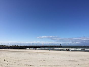 Scenic view of beach against blue sky