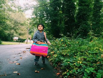 Boy walking with bag on street