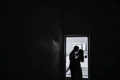 Man and woman standing against window