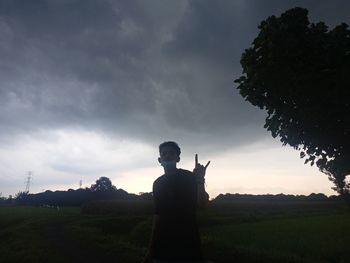 Man standing on field against sky