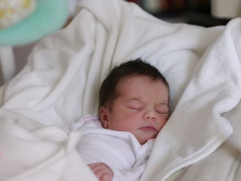 Close-up of cute baby sleeping on bed at home