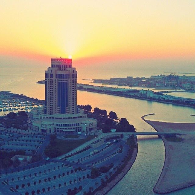 sunset, sea, architecture, orange color, built structure, building exterior, water, city, cityscape, horizon over water, sky, sun, high angle view, clear sky, scenics, travel destinations, transportation, travel, beach, nature