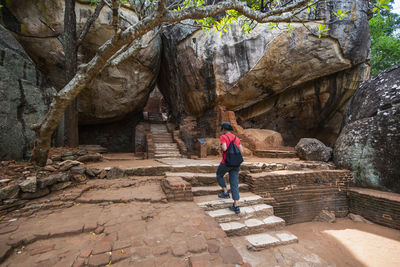 Rear view of woman walking on rock