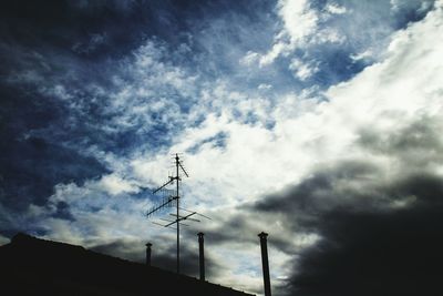 Low angle view of power lines against cloudy sky