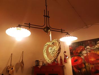 Low angle view of illuminated lighting equipment against sky