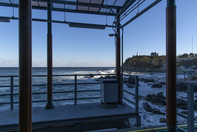 Scenic view of sea against clear sky seen through mono rail station 