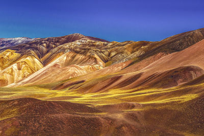 Scenic view of mountains against clear blue sky