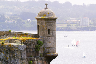 Fort sentry with sailboats in background , coruna bay in  galicia , spain