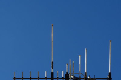 Low angle view of smoke stack against clear blue sky