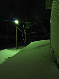 View of snow covered street at night