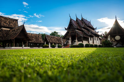 Exterior of temple on field against sky