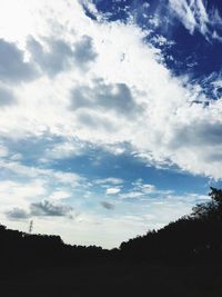 Silhouette landscape against cloudy sky