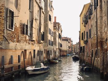 Canal amidst buildings in venice against clear sky