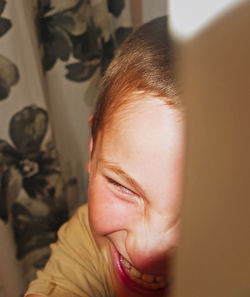 Close-up of cheerful teenage boy at home