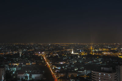 Illuminated buildings in city against sky at night