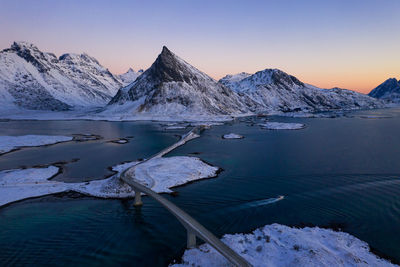 Scenic view of lake and snowcapped mountains against sky during winter