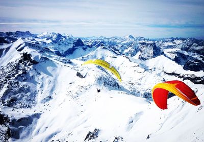 Parachute flying over swiss alps against sky