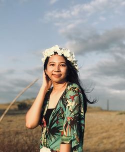 Portrait of smiling young woman standing against the sky