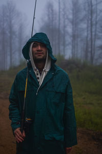 Young man standing in forest during winter