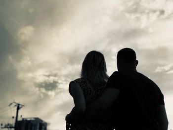 Rear view of couple standing against sky