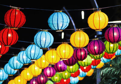 Low angle view of illuminated lanterns hanging at night