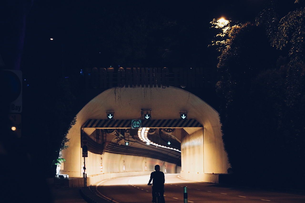 real people, built structure, night, architecture, illuminated, men, women, silhouette, lifestyles, arch, leisure activity, tree, two people, city, standing, outdoors, building exterior, sky, nature, people