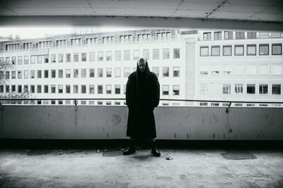 Rear view of woman standing against building in city