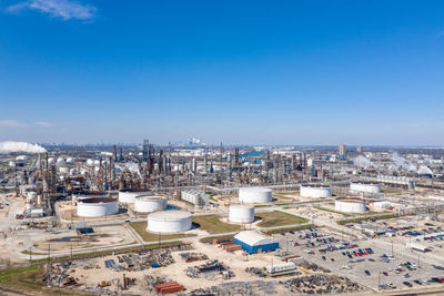 High angle view of buildings in city against blue sky