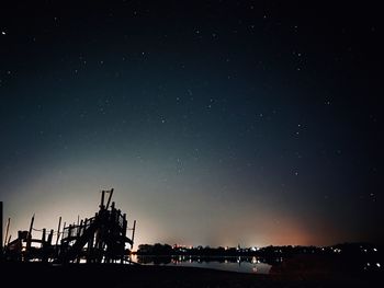 Silhouette of playground against sky at night