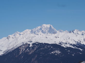 Scenic view of snowcapped mountains against clear blue sky