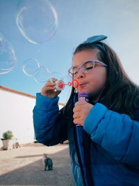 Full length of woman holding bubbles